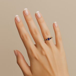 Mão vestindo o Anel de formatura Tríade em ouro 18k, com três safiras, para os cursos de administração engenharia, psicologia, entre vários outros